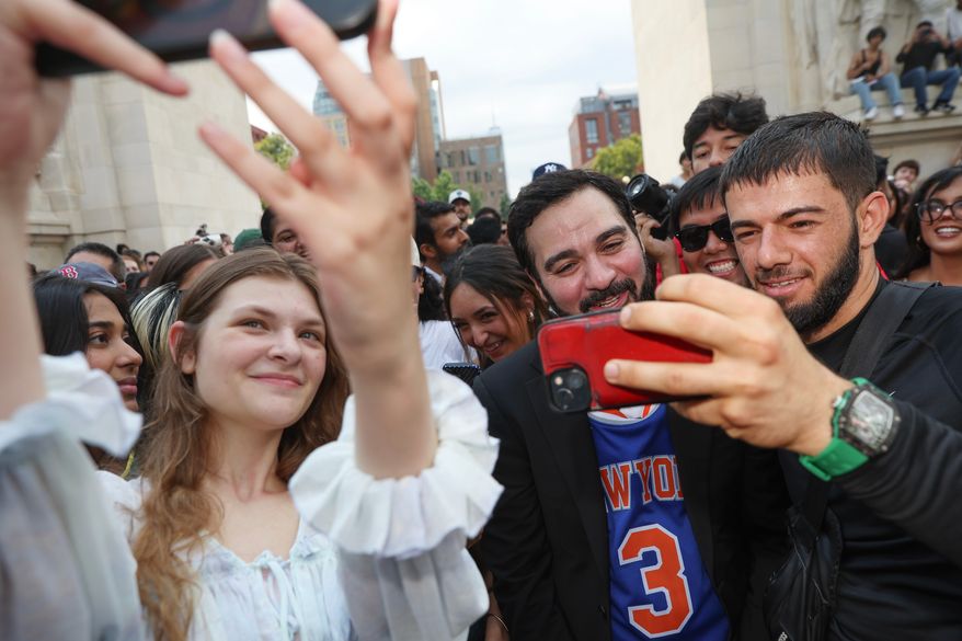 Amadeo Fusca, center, winner of the Mayor Zohran Mamdani look-alike contest, takes selfies with the crowd, Sunday, Aug. 30, 2026, in New York. (AP Photo/Heather Khalifa)