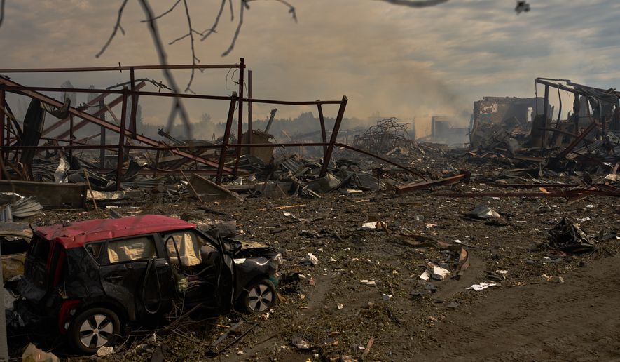 Destroyed vehicles and debris are scattered the day after a Russian attack struck a warehouse, followed by an explosion, in the village of Myla, outskirts of Kyiv, Sunday, Aug. 30, 2026. (AP Photo/Francisco Seco)