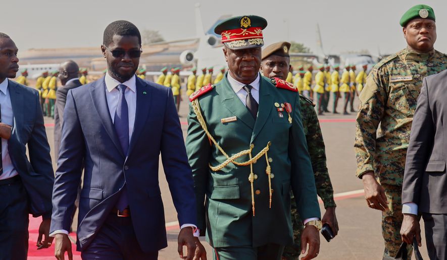 FILE - Guinea-Bissau Transitional President General Horta Inta-A-Na Man, centre, and President of Senegal Bassirou Diomaye Faye walk during an official ECOWAS mission to help resolve Guinea-Bissau's political crisis in Bissau, Guinea-Bissau, on Jan. 10, 2026. (AP Photo/Abubacar Queta, File)