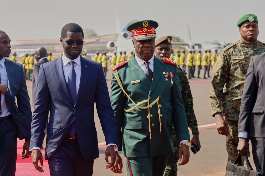 FILE - Guinea-Bissau Transitional President General Horta Inta-A-Na Man, centre, and President of Senegal Bassirou Diomaye Faye walk during an official ECOWAS mission to help resolve Guinea-Bissau's political crisis in Bissau, Guinea-Bissau, on Jan. 10, 2026. (AP Photo/Abubacar Queta, File)