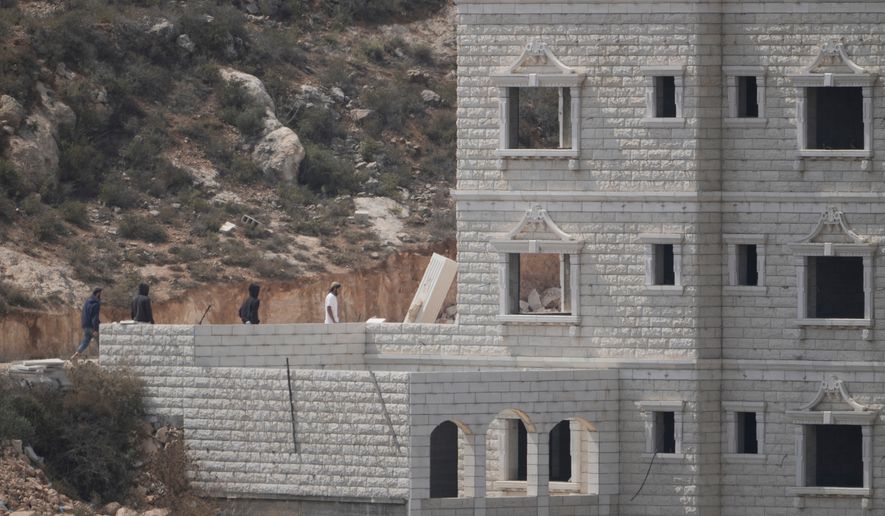 Israeli settlers enter Palestinian properties in the occupied West Bank village of Qusra, Saturday, Aug. 29, 2026. (AP Photo/Majdi Mohammed)