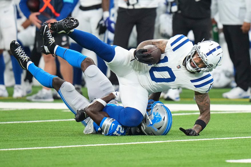 Indianapolis Colts wide receiver Keenan Allen (10) is tackled by Detroit Lions cornerback Roger McCreary (21) during the first half of a preseason NFL football game in Indianapolis, Saturday, Aug. 29, 2026. (AP Photo/AJ Mast)