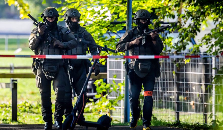 Armed police officers patrol near the Schachen horse racing track in Aarau following a shooting during a rave event near Aarau, Switzerland, Sunday, Aug. 30, 2026. (Michael Buholzer/Keystone via AP)