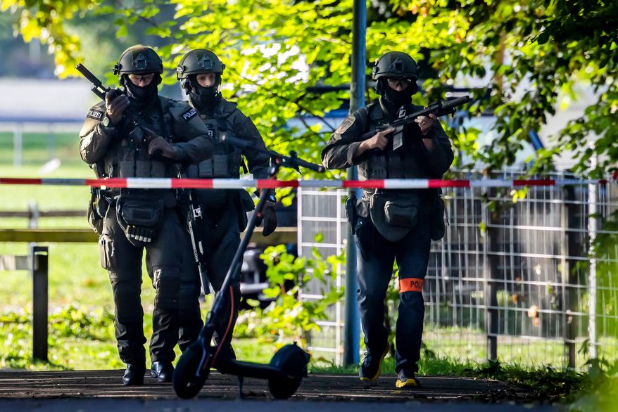 Armed police officers patrol near the Schachen horse racing track in Aarau following a shooting during a rave event near Aarau, Switzerland, Sunday, Aug. 30, 2026. (Michael Buholzer/Keystone via AP)