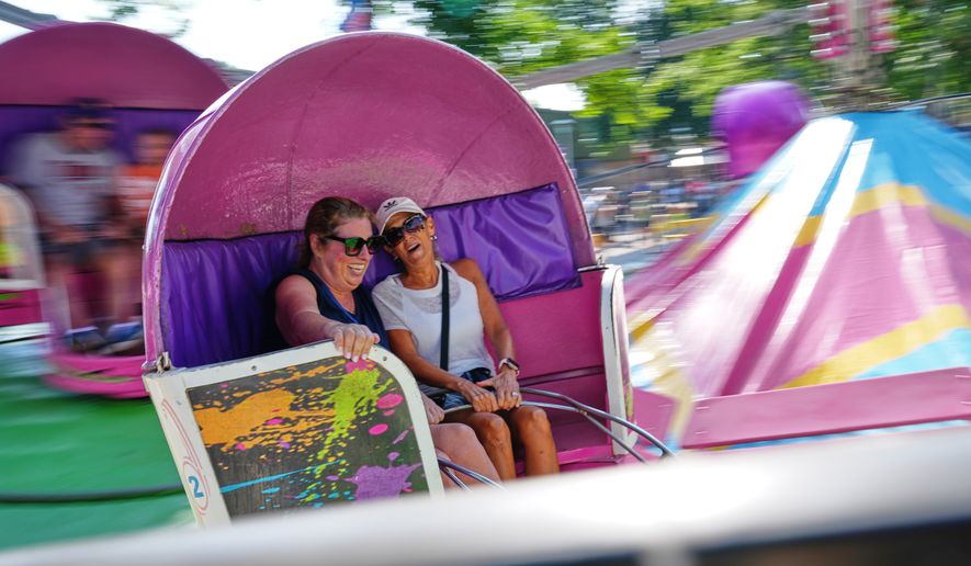 Valerie Nelson, left, and Sherri Gray ride the Tilt-A-Whirl, Thursday, Aug. 27, 2026, at the Minnesota State Fair in Falcon Heights, Minn. (AP Photo/Ellen Schmidt)