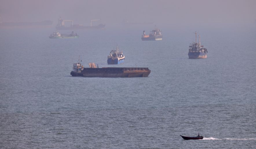FILE - A small boat sails past cargo ships and other commercial vessels anchored in the Strait of Hormuz off Bandar Abbas, Iran, Wednesday, Aug. 5, 2026. (Amirhosein Khorgooi/ISNA via AP, File)