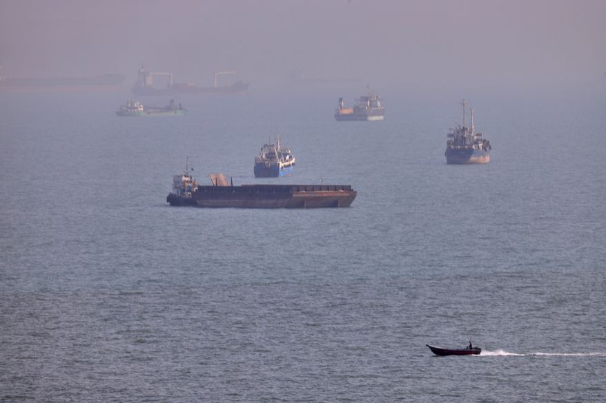 FILE - A small boat sails past cargo ships and other commercial vessels anchored in the Strait of Hormuz off Bandar Abbas, Iran, Wednesday, Aug. 5, 2026. (Amirhosein Khorgooi/ISNA via AP, File)