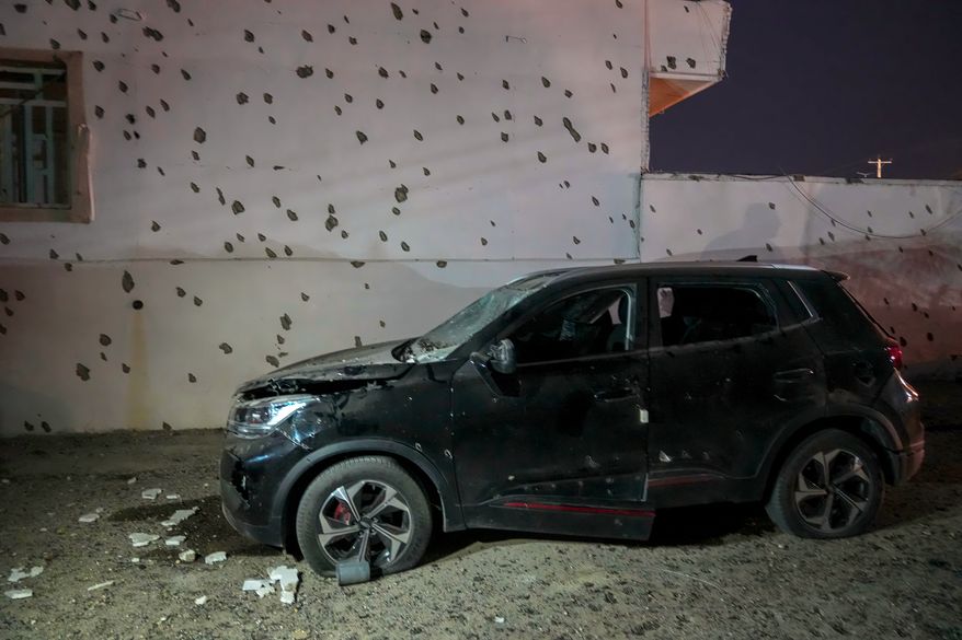 A damaged car sits beside a wall bearing numerous impact marks near the site of a strike in Lamerd, southern Iran, Saturday, Feb. 28, 2026. (Alireza Ameri/Tasnim News Agency via AP)