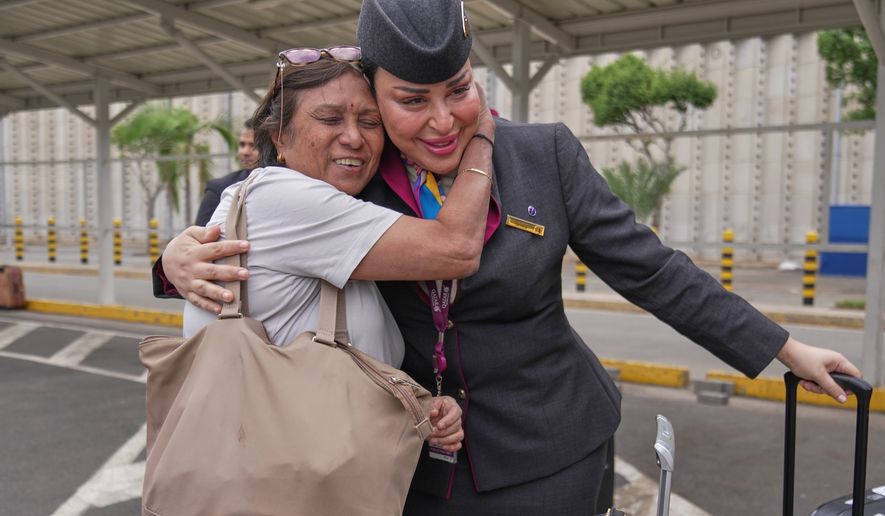 A passenger hugs a Qatar Airways flight attendant after a delayed flight was cleared for departure during a workers strike at Jomo Kenyatta International Airport, in Nairobi, Kenya, Monday, Aug. 31, 2026. (AP Photo/Brian Inganga)