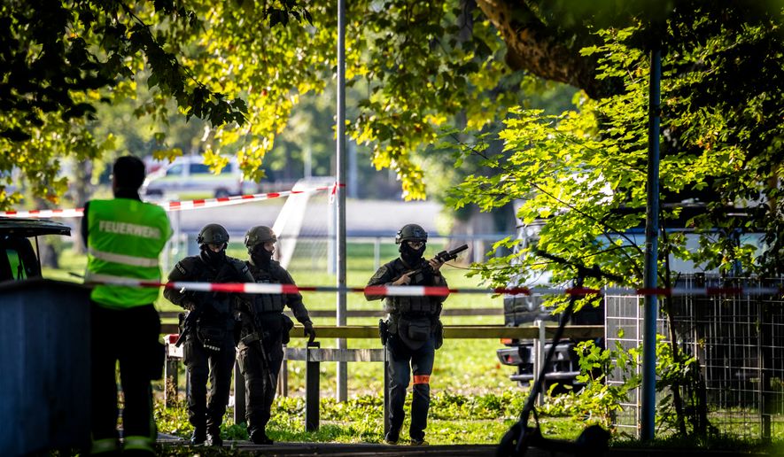 Police officers secure the area around the Schachen horse racing track following a shooting at a rave, in Aarau, Switzerland, Sunday Aug. 30, 2026. (Michael Buholzer/Keystone via AP)