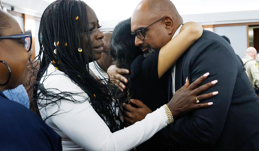 Friends and family members of rapper Tupac Shakur, including his sister Sekyiwa Shakur, second left, line up to hug Chief Deputy District Attorney Binu Palal, right, after a jury found Duane Davis guilty of first-degree murder in his trial related to the 1996 killing of rapper Tupac Shakur, at Clark County District Court Regional Justice Center, Monday, Aug. 31, 2026, in Las Vegas. (Bizuayehu Tesfaye/Las Vegas Review-Journal via AP, Pool)