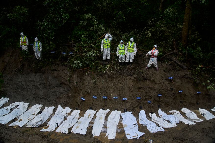 Nepal police personnel prepare the bodies of flash flood victims for a mass burial in Kathmandu, Nepal, Tuesday, Sept. 1, 2026. (AP Photo/Niranjan Shrestha)