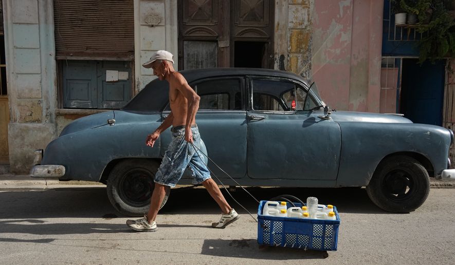 A man pulls a cart carrying drinking water during a power outage in Havana, Cuba, Monday, Aug. 3, 2026. (AP Photo/Ramon Espinosa)