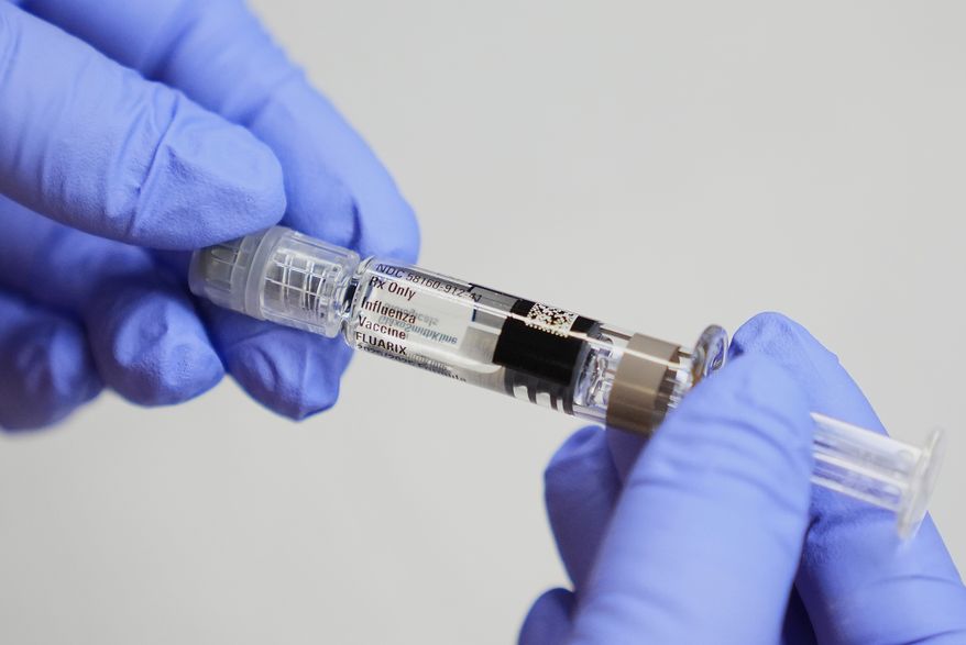 FILE - A certified medical assistant holds a syringe for a flu vaccine at a clinic in Seattle, on Sept. 10, 2025. (AP Photo/Lindsey Wasson, File)