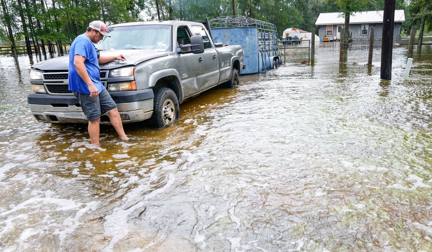 Chase Barfield walks to his truck as he takes belongings and his dogs away from floodwaters around his house in the aftermath of Tropical Storm Edouard near Honey Island, Texas, Wednesday, Sept. 2, 2026. (Brett Coomer/Houston Chronicle via AP)