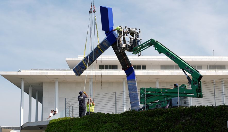 Workers remove the sculpture "Blue" by artist Joel Shapiro on the grounds of the John F. Kennedy Center for the Performing Arts in Washington, Wednesday, Sept. 2, 2026. (AP Photo/Mark Schiefelbein)