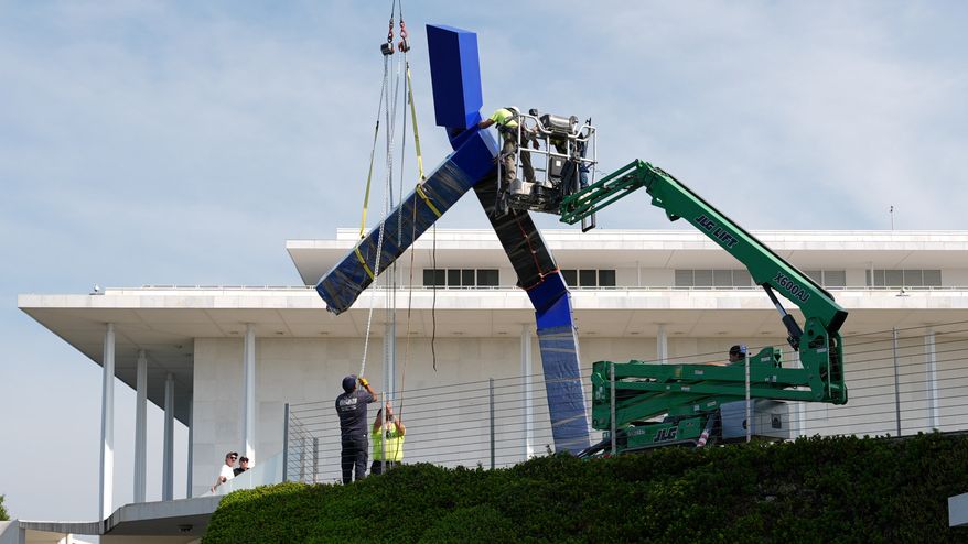 Workers remove the sculpture "Blue" by artist Joel Shapiro on the grounds of the John F. Kennedy Center for the Performing Arts in Washington, Wednesday, Sept. 2, 2026. (AP Photo/Mark Schiefelbein)