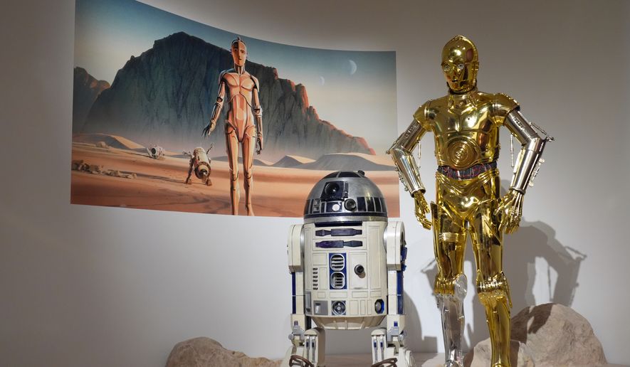Production designer Norman Reynolds' robot R2-D2, left, and John Mollo's costume for the C-3PO character from the "Star Wars" franchise are displayed in the Cinema Gallery during a preview of the Lucas Museum of Narrative Art on Monday, Aug. 31, 2026, in Los Angeles. (AP Photo/Chris Pizzello)