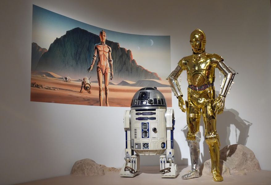 Production designer Norman Reynolds' robot R2-D2, left, and John Mollo's costume for the C-3PO character from the "Star Wars" franchise are displayed in the Cinema Gallery during a preview of the Lucas Museum of Narrative Art on Monday, Aug. 31, 2026, in Los Angeles. (AP Photo/Chris Pizzello)