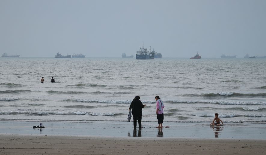 People spend time at a beach as commercial vessels are anchored in the Strait of Hormuz off Bandar Abbas, Iran, Wednesday, Sept. 2, 2026. (Razieh Poudat/ISNA via AP)