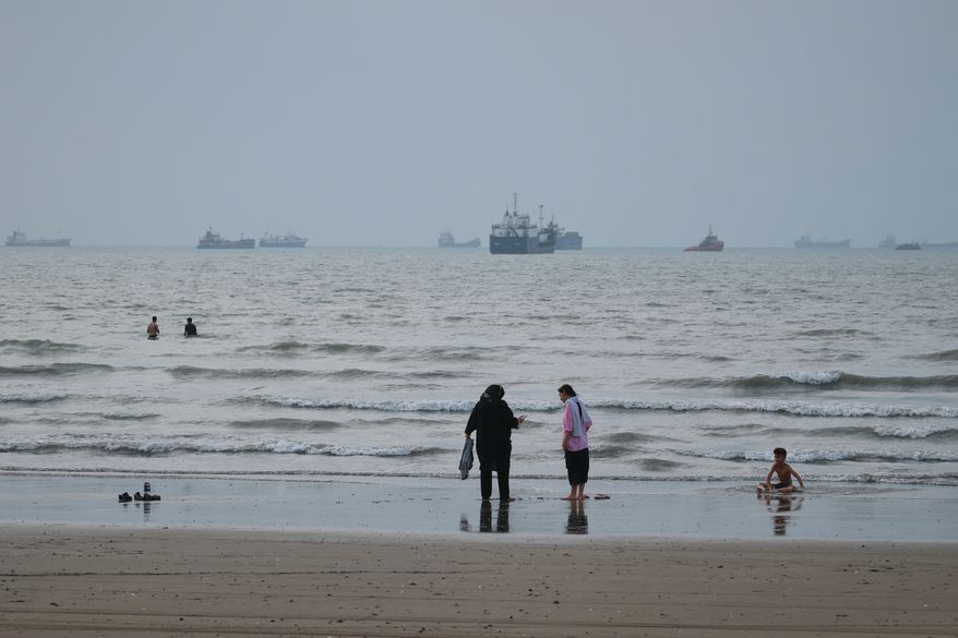 People spend time at a beach as commercial vessels are anchored in the Strait of Hormuz off Bandar Abbas, Iran, Wednesday, Sept. 2, 2026. (Razieh Poudat/ISNA via AP)
