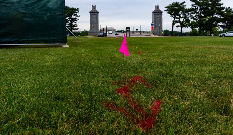Flags are placed as workers survey the Memorial Circle, where President Donald Trump has proposed building an arch to commemorate the United States' 250th anniversary, May 11, 2026, in Washington. (AP Photo/Alex Brandon, File)