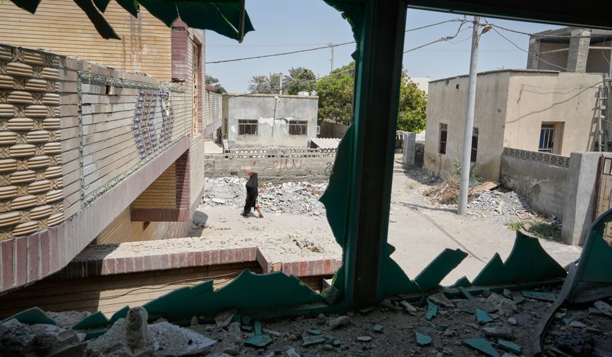 A person walks past debris, seen through a shattered window at the site of what Iranian media said was a U.S. strike on a home where a wedding celebration was being held late Tuesday, Sept. 1, in Kuhestak, southern Iran, Friday, Sept. 4, 2026. (AP Photo/Vahid Salemi)
