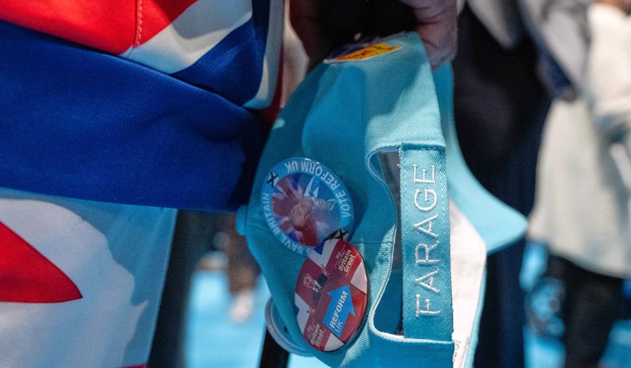 A member carrys a hat during the Reform party's annual conference at the National Exhibition Centre in Birmingham, England, Friday, Sept. 4, 2026. (AP Photo/Thomas Krych)