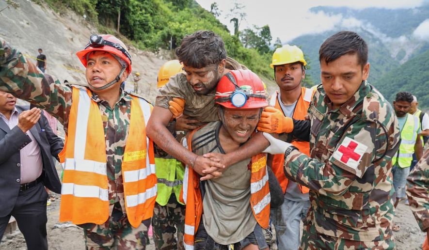 In this photo provided by the Nepal Army, soldiers rescue a worker alive from a tunnel during an ongoing operation at the Trishuli-3A hydropower project in Nepal's Rasuwa district, Friday, Sept. 4, 2026. (Nepal Army via AP)