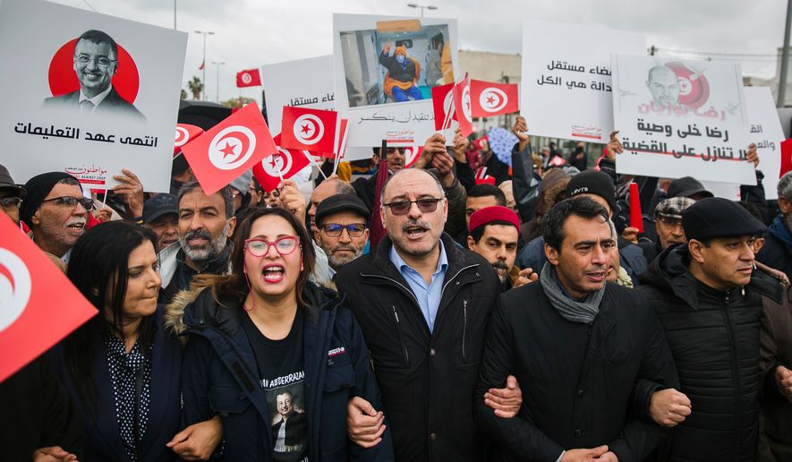FILE - Tunisian constitutional law professor Jaouhar Ben Mbarek, second from right, and Tunisian politician Samira Chaouachi, left, shout slogans during a protest against Tunisian president Kais Saied on the anniversary of Tunisia's independence in Tunis, Tunisia, March 20, 2022. (AP Photo/Hassene Dridi, File)
