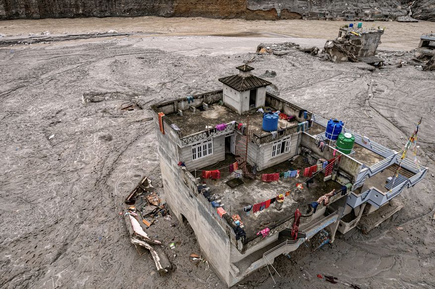 A drone view shows a damaged residential building along the swollen Trishuli River in the aftermath of flash floods in Nepal's Nuwakot district, Thursday, Sept. 3, 2026. (AP Photo/Rajesh Kumar Singh)