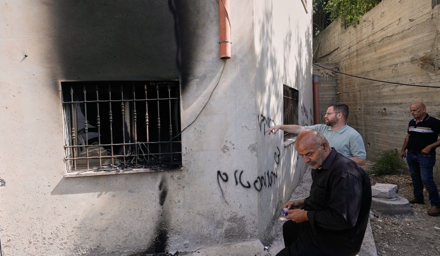 Palestinians check the damage to a mosque that, according to residents, was burned during an attack by Israeli settlers, in the West Bank village of Bazariya, Tuesday, Sept. 1, 2026, as on its wall a Hebrew graffiti reads "Huckabee regards from the terrorists", referring to the U.S. Ambassador to Israel, Mike Huckabee. (AP Photo/Majdi Mohammed)