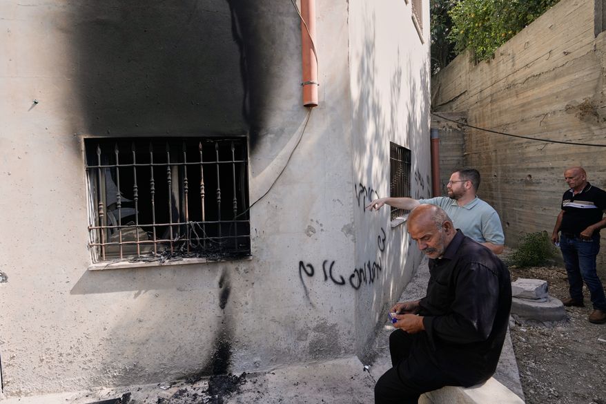 Palestinians check the damage to a mosque that, according to residents, was burned during an attack by Israeli settlers, in the West Bank village of Bazariya, Tuesday, Sept. 1, 2026, as on its wall a Hebrew graffiti reads "Huckabee regards from the terrorists", referring to the U.S. Ambassador to Israel, Mike Huckabee. (AP Photo/Majdi Mohammed)