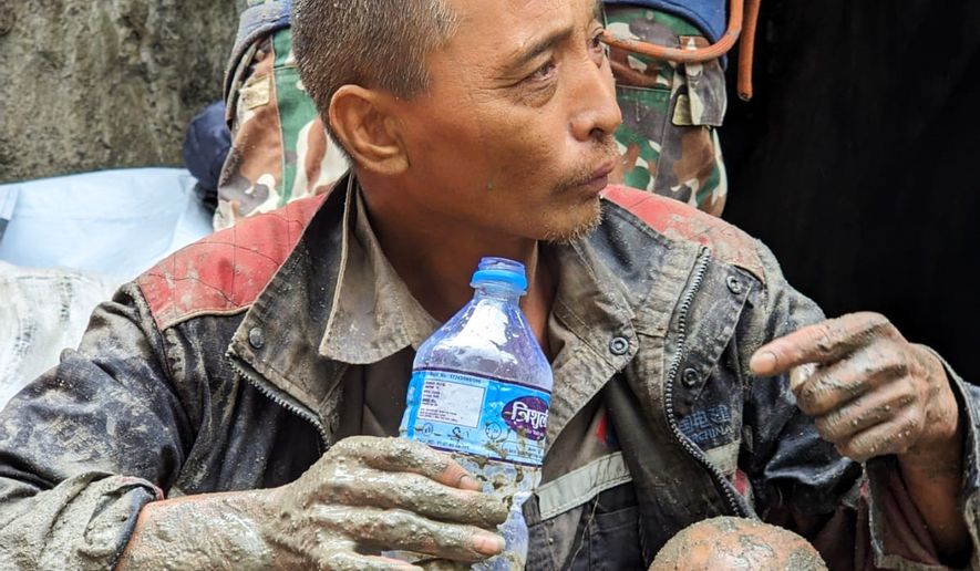 In this photo provided by the Nepal Army, a Chinese national is seen drinking water after being rescued by soldiers during an ongoing operation at the Trishuli-3A hydropower project in Nepal's Rasuwa district, Saturday, Sept. 5, 2026. (Nepal Army via AP)