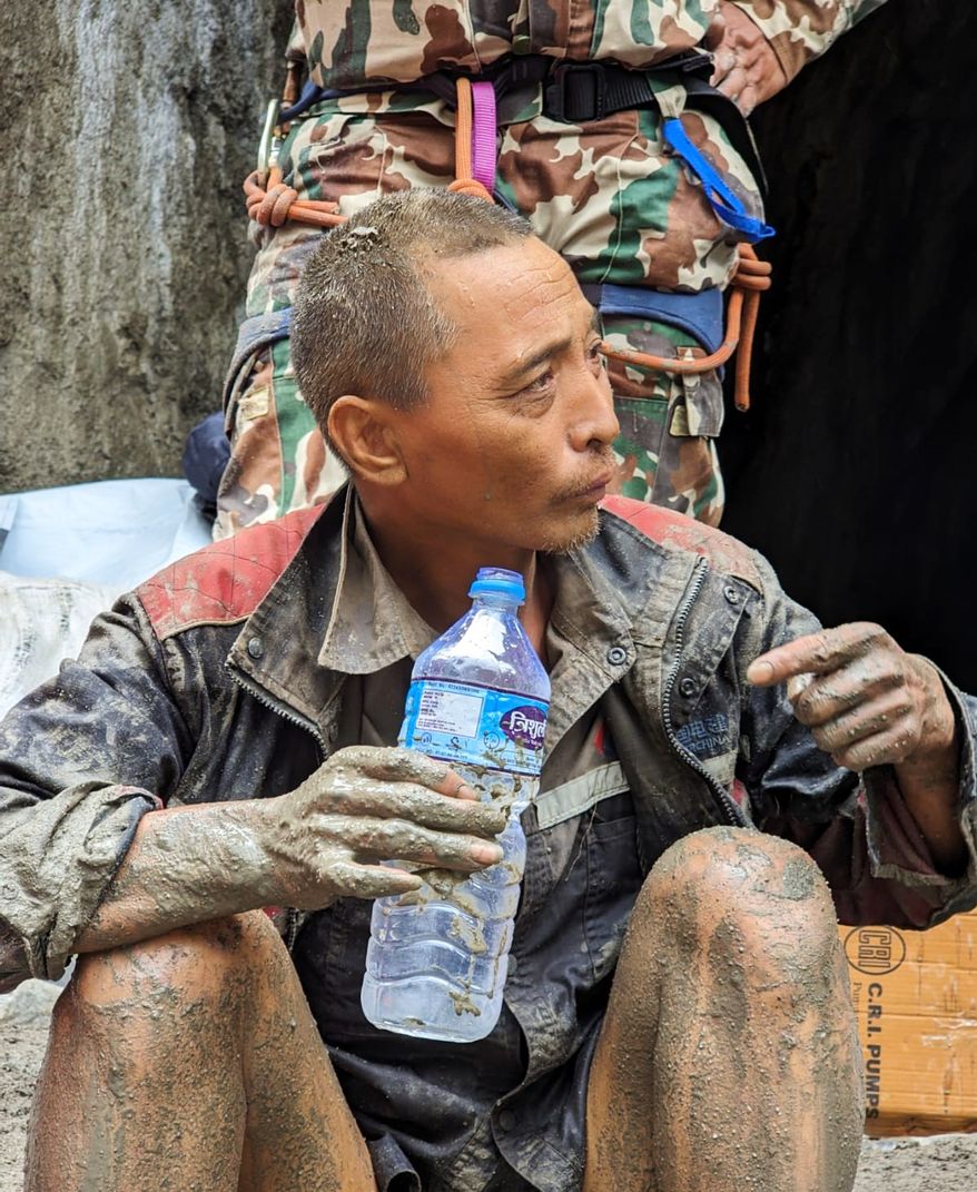 In this photo provided by the Nepal Army, a Chinese national is seen drinking water after being rescued by soldiers during an ongoing operation at the Trishuli-3A hydropower project in Nepal's Rasuwa district, Saturday, Sept. 5, 2026. (Nepal Army via AP)