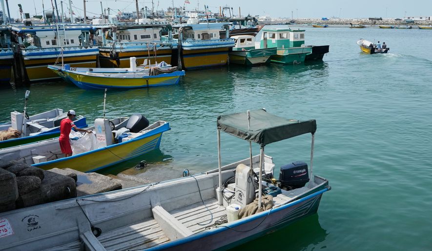 A man works aboard a boat as a motorboat leaves a harbor in Bandar Abbas, Iran, Sunday, Sept. 6, 2026. (AP Photo/Vahid Salemi)