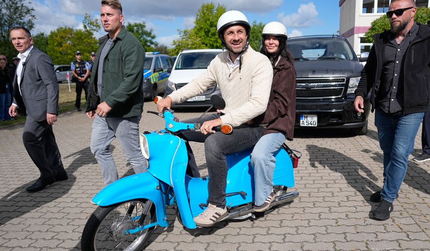 Ulrich Siegmund, top candidate for the "Alternative for Germany" (AfD) party and his wife Julia leaving a polling station on a small Schwalbe motorcycle after voting during the Saxony-Anhalt state elections in Tangermuende, eastern Germany, Sunday, Sept. 6, 2026. (AP Photo/Matthias Schrader)