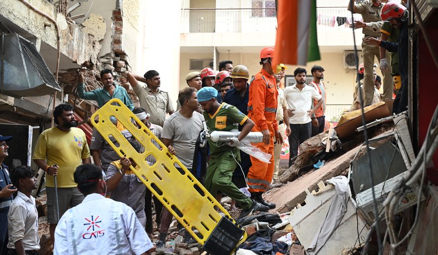Rescue workers look for the trapped survivors under the debris of a building that collapsed in New Delhi, India, Sunday, Sept. 6, 2026. (AP Photo/ Vipin)