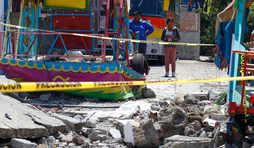 Residents look at the area destroyed by a fireworks explosion by Santa María Canchesdá church in Temascalcingo, Mexico, Sunday, Sept. 6, 2026. (AP Photo/Ramses Mercado)