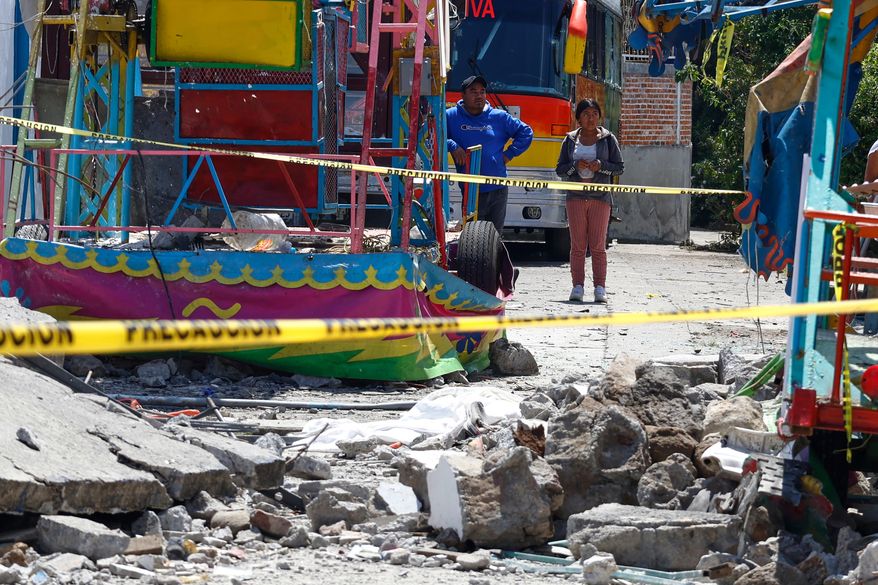 Residents look at the area destroyed by a fireworks explosion by Santa María Canchesdá church in Temascalcingo, Mexico, Sunday, Sept. 6, 2026. (AP Photo/Ramses Mercado)