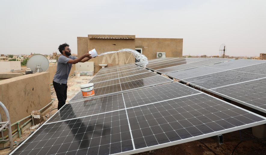 A technician cleans solar panels installed on the roof of a home in Omdurman, on the outskirts of Khartoum, Sudan, July 23, 2026. (AP Photo/Mohnd Blal)