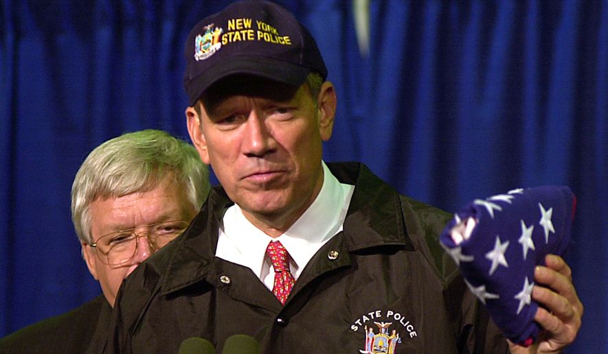 New York Gov. George Pataki holds an American flag, which earlier flew over the capital, that was given to him by House Speaker Dennis Hastert, back left, Monday, Oct. 1, 2001, in New York. More than 100 congressional members toured the site of the World Trade Center. (AP Photo/Tony Gutierrez)