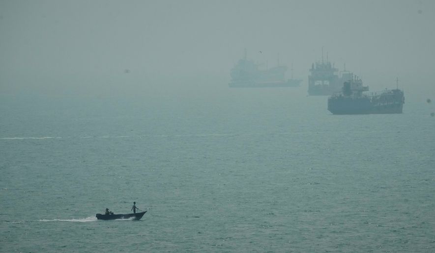 A motorboat travels past commercial vessels anchored amid haze in the Strait of Hormuz off Bandar Abbas, Iran, Monday, Sept. 7, 2026. (AP Photo/Vahid Salemi)
