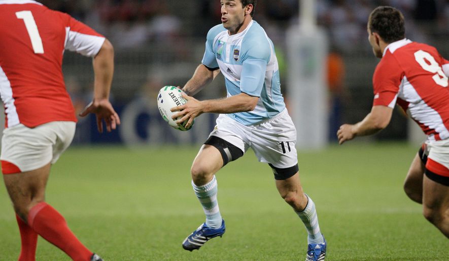 File - Argentina's Federico Martin Aramburu, center, runs with the ball during their Rugby World Cup Group D match between Argentina and Georgia, in Lyon, France, on Sept.11, 2007. (AP Photo/Mark Baker, File)
