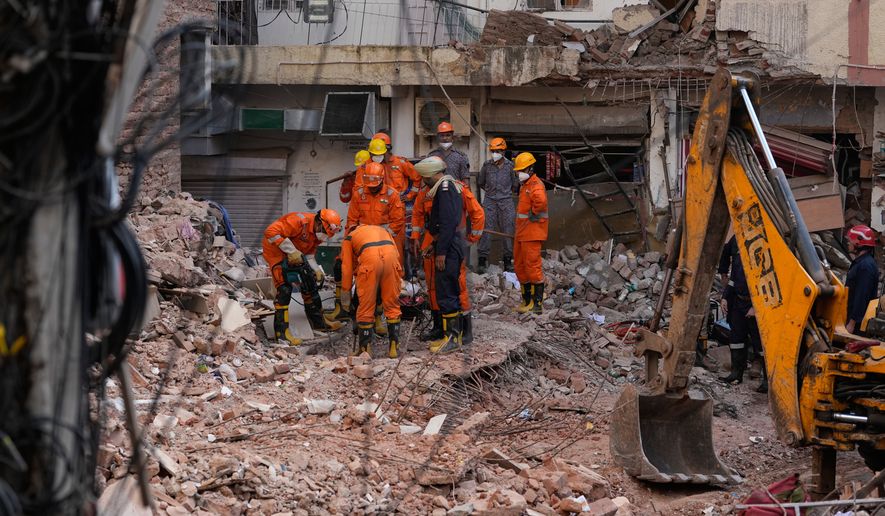 Rescue workers continue to search for people trapped under the debris of a collapsed building in New Delhi, India, Monday, Sept. 7, 2026. (AP Photo/Manish Swarup)