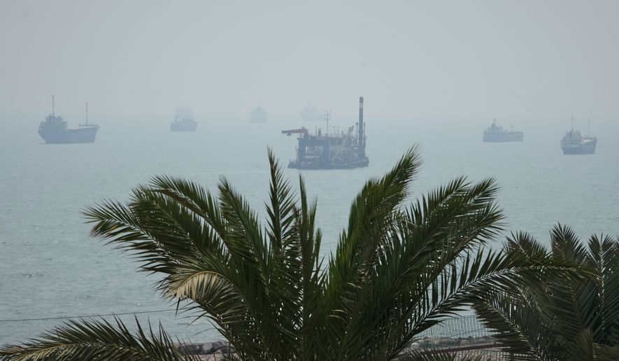 A floating dredging platform and commercial vessels lie anchored amid haze in the Strait of Hormuz off Bandar Abbas, Iran, Monday, Sept. 7, 2026. (AP Photo/Vahid Salemi)
