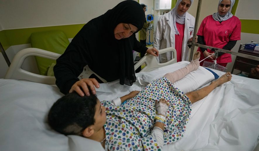 Mustafa Farhat, 8, who was injured in an Israeli airstrike that hit his home and killed his parents, is comforted by his grandmother at a hospital in the town of Nabatiyeh, southern Lebanon, Monday, Sept. 7, 2026. (AP Photo/Mohammed Zaatari)