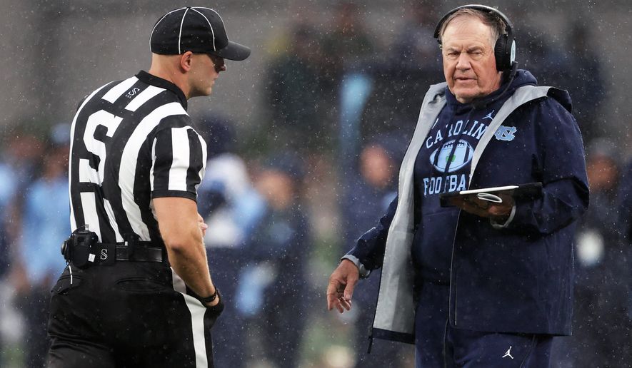 North Carolina head coach Bill Belichick, right, speaks with an official during an NCAA college football game against TCU in Dublin, Ireland, Saturday, Aug. 29, 2026. (AP Photo/Peter Morrison)