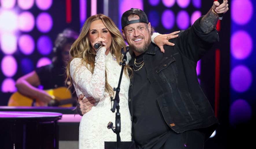 Jelly Roll makes a surprise appearance with Carly Pearce as she performs Dolly Parton's, 9 to 5, during a show dedicated to the late Dolly Parton at the Grand Ole Opry, Saturday, Aug. 29, 2026, in Nashville, Tenn. (AP Photo/Adin Parks)