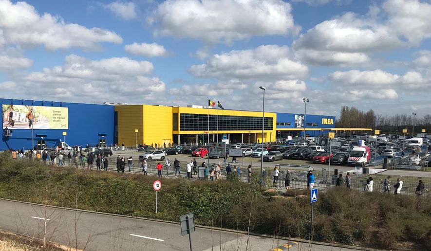 FILE- People stand in a line for last minute shopping outside an Ikea store in Brussels, Friday, March 26, 2021. (AP Photo/Mark Carlson, File)